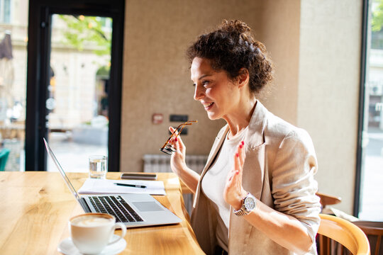 Smiling businesswoman on video call in cafe