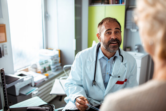 Doctor consulting senior patient in clinic