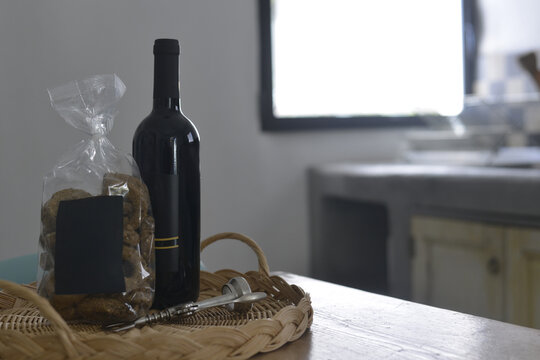 Bottiglia di vino nero con una busta di taralli in una cucina di un'antica masseria