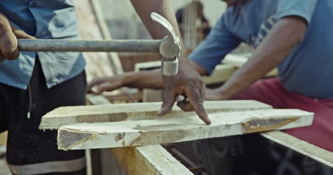 Construction workers tying steel rebar for beams and pillars, and hammering nails, capturing real on-site building process and structural work