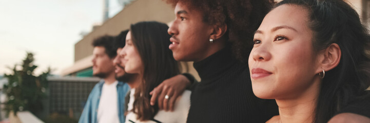 Obraz premium Close-up of young people, guys and girls friends standing hugging each other on the balcony looking at the beautiful views. Panoramic