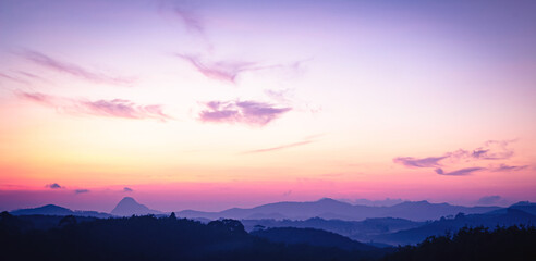 Fototapeta premium Panoramic sunrise over mountain ridge with vibrant purple and pink pastel sky, inspirational nature background and sky replacement banner