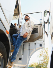 Indian truck driver smiling stepping into vehicle © Serhii