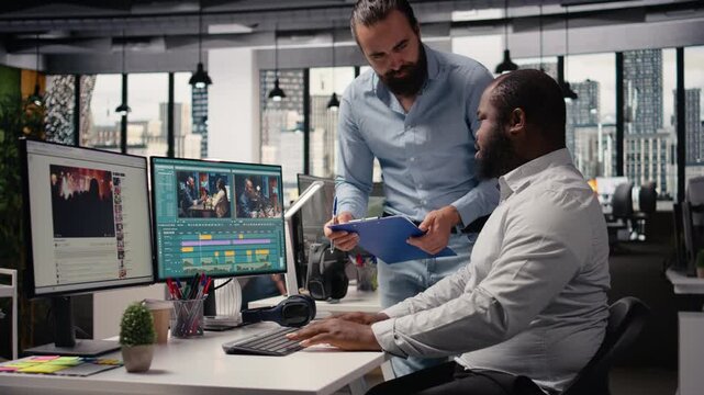 Filmmakers team, editing video footage, dual monitors in creative office, staff editing process for montage with transitions. Color grading and cutting clips for motion graphics production.