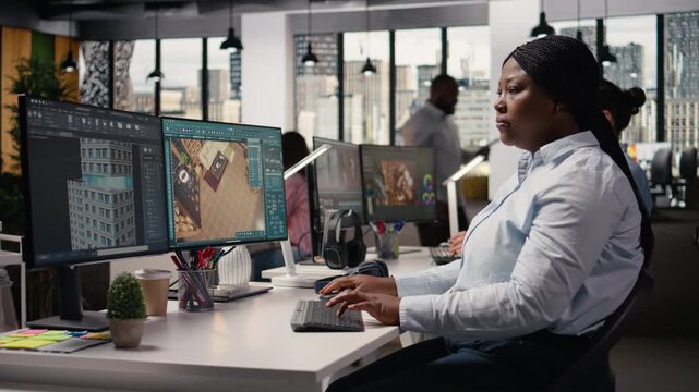 Black female graphic designer using remodeling software for modern floor plan, 3D rendering program on computer. Architectural developer with virtual assets used for new layout.