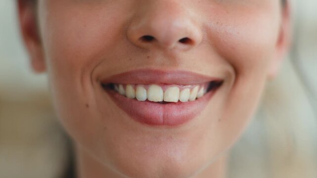 Close up female mouth smiling showing healthy white teeth dental oral care Indian Arabian woman unrecognizable girl whitening clinic medicine health toothy smile lady beauty detail indoors apartment