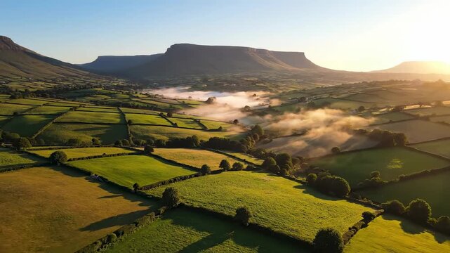 Breathtaking Aerial View of Misty Green Valleys, rolling hills and patchwork fields under a golden sunrise with flat-topped mountains, perfect for travel documentaries and nature backgrounds.
