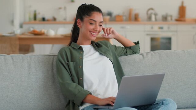 Happy Indian woman at home using laptop celebrating win victory good exam result online smiling girl excited ethnic Arabian female student freelancer browsing computer lucky success achievement indoor