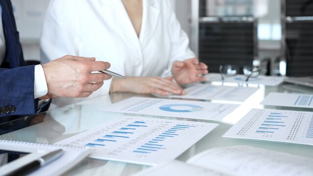 Business executive hands on contract paper with pen, preparing to sign an agreement during a meeting, representing corporate deal negotiation and legal process