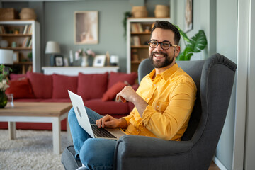 Happy man working remotely from home living room © Jelena
