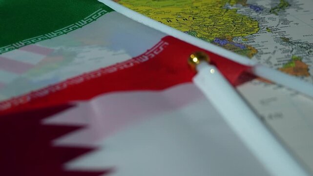 A detailed close-up of a Qatar flag's eyelet with a world map beneath.