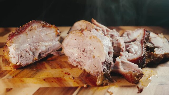 Close-up video of sliced boneless pork joint on a wooden board with steam rising. The meat is juicy and tender inside with caramelized crispy edges, showcasing texture, heat and slow cooked perfection
