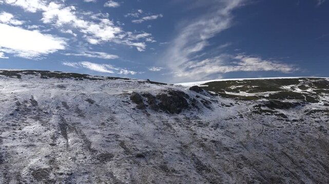 Timelapse of Atlas Mountains ridge in Morocco Algeria, treeless hillside under first winter snow. Accelerated clouds over Maghreb highlands, barren curved plateau dusted by initial cold season frost.