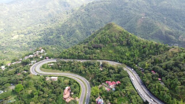 Aerial view from drone approaching curve road in la vega town in cundinamarca Colombia, Mountains arround blue sky