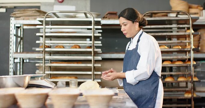 Diverse female bakers shaping, weighing dough using scale in bakery, assistant entering for baking