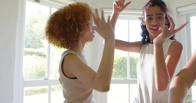 African American women modeling for photographer, making gestures and adjusting hair by bay windows