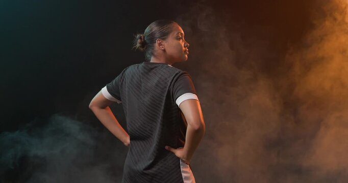Adult African American woman responding to shoot cue, turning in athletic top amid teal amber fog