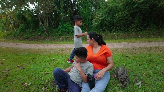 Hispanic mother resting with her sons in a public park