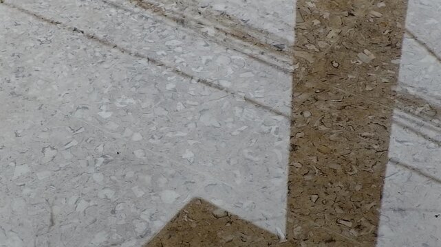 Flooded gray stone floor with waterdrops making small ripples