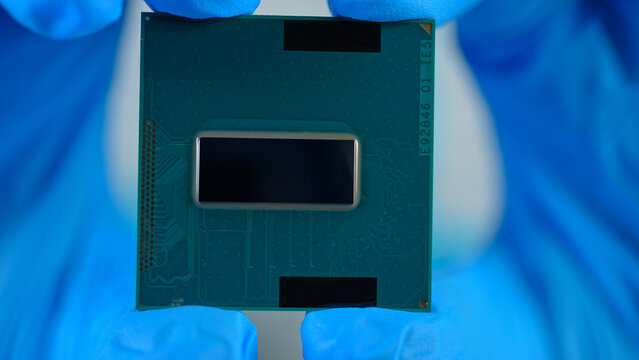 CPU in scientists or engineer hand, concept of semiconductor and microchips shortage along with sanctions and geopolitical tensions, critical mineral embargo and rear earth mining. Blockchain concept.