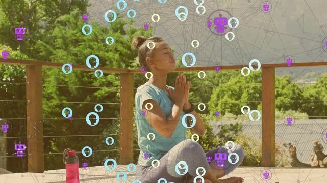 Vertical video: Woman sitting on yoga mat on deck meditating into prayer as avatars descend