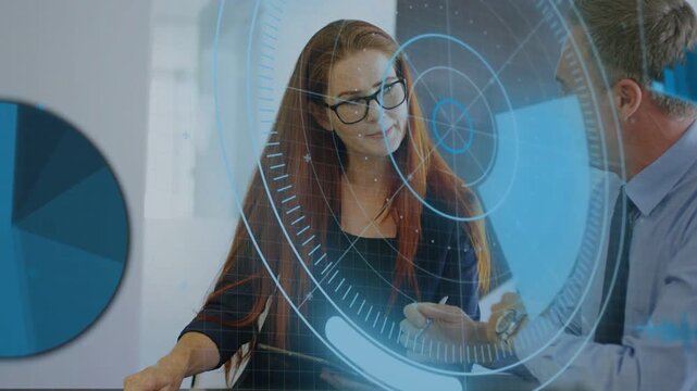 Woman holding tablet tapping after man leaning and pointing, blue HUD sweeping business data