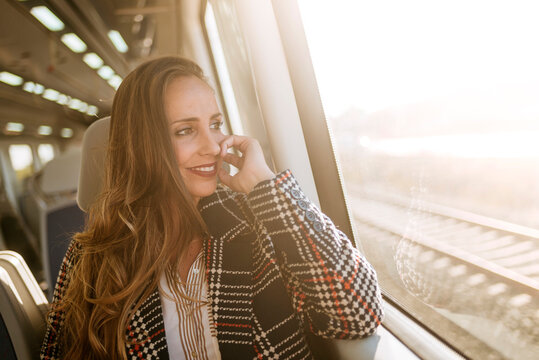Businesswoman relaxing and looking out train window during travel