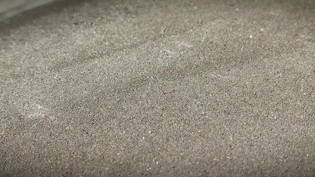 Shot of gray mineral plaster texture. Close-up of grainy surface with shimmering particles. Authentic candid style, professional construction finishing material, macro