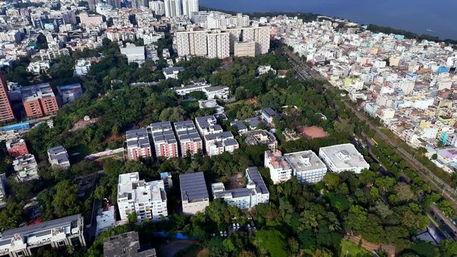Wide aerial view of Hyderabad highlighting clusters of solar-powered rooftops, modern buildings, and lush green surroundings, reflecting renewable energy integration within a growing cityscape.