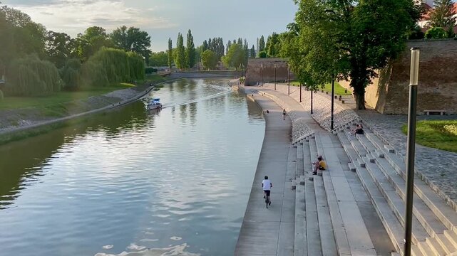 Peaceful lake with small boat and park at dusk in Győr, Hungary