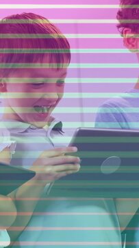 Vertical video: Children tapping tablets in school, initiating stripe overlay and sharing smiles