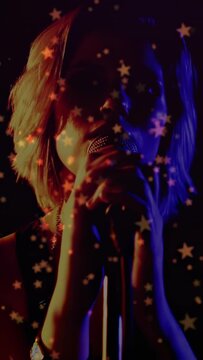 Vertical video: Singer raising arm to mic, cupping mic and singing for close take with star overlay