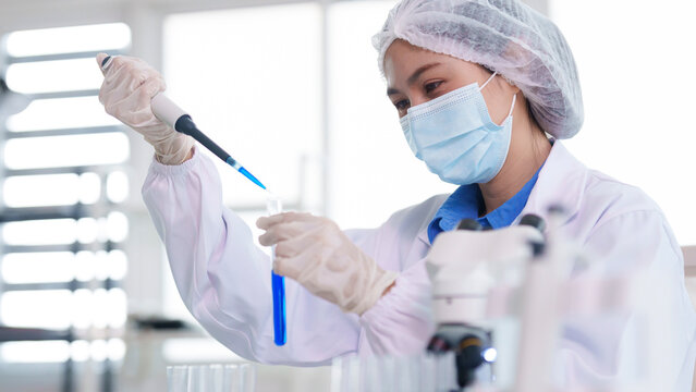 Asian adult scientist conducting chemical research laboratory analysis using micropipette test tube medical experiment biology lab work development