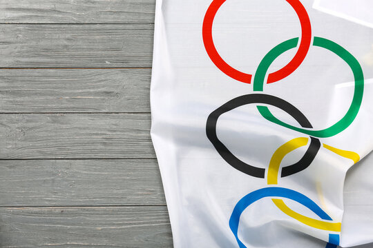 Olympic flag on grey wooden background