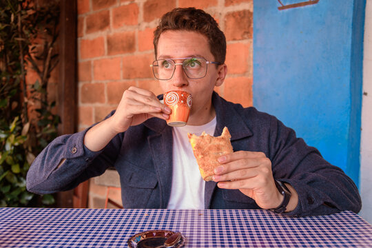 Man Eating Traditional Mexican Pastry and Drinking Coffee