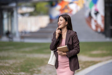 Fototapeta premium Professional asian woman thinking outdoors exploring city life