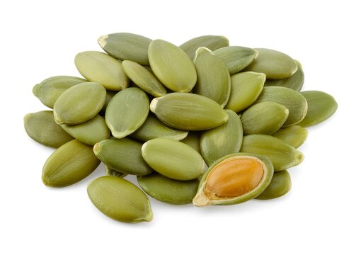 Pile of green pumpkin seeds with one split open pepitas