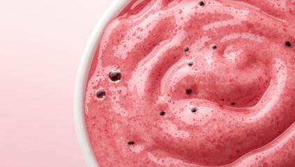 Fototapeta premium Smooth pink smoothie bowl with creamy texture and scattered berry seeds, bright appetizing look
