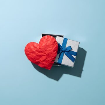 Gift and heart on light blue background a symbol of love and appreciation
