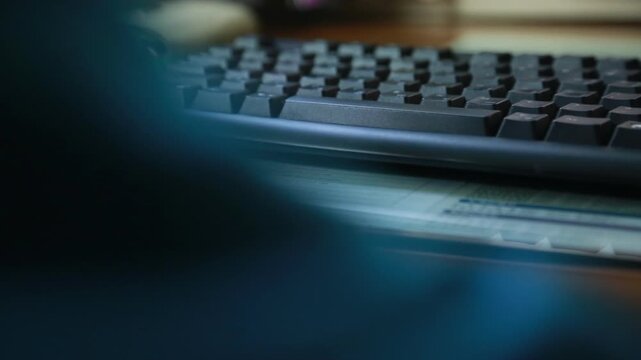 한국의 사무실 책상에서 손가락에 반지를 낀 남성이 검은색 키보드로 업무를 보는 핸드헬드 브이로그 영상