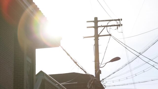 한국 서울 주택가의 전신주 사이로 강렬하게 비치는 아침 햇살과 렌즈 플레어 핸드헬드 브이로그 영상