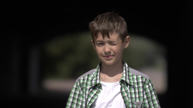funny boy look into the camera and squint from the sun, have fun and enjoy