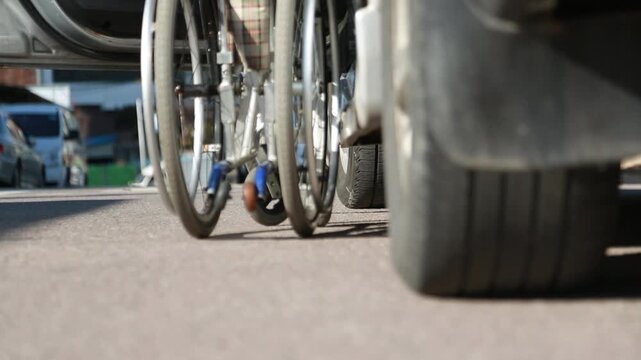 한국의 야외 도로 위에서 장애인 전용 차량 리프트를 통해 자동으로 내려오는 휠체어 뒷모습 핸드헬드 브이로그 영상