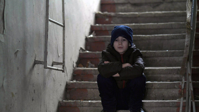 hooligan boy sits alone in an old ramshackle building, demolition house, have fun and enjoy