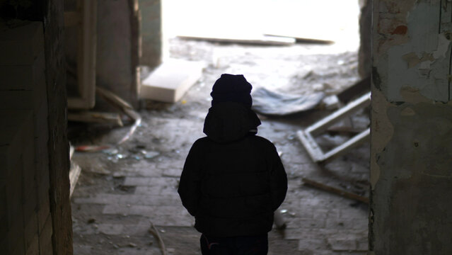 boy is standing in an old ruined house, demolition old ramshackle building, have fun and enjoy