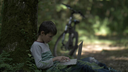 boy cyclist reading book near tree in forest, have fun and enjoy © vla