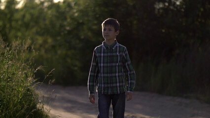 Obraz premium Serious boy walking on the countryside road, have fun and enjoy