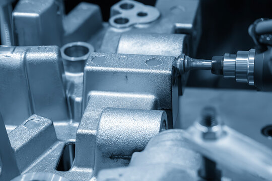 Industrial robotic arm performing precision deburring and chamfering on aluminum casting parts.