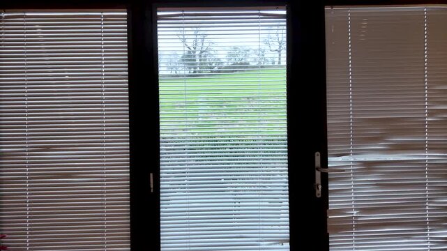Blinds on bi fold glass doors controlling light and privacy with countryside view. push forward