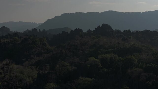 Morning light shines up the karst formations of the Thakhek area in southern Laos as the camera pans across the scene.